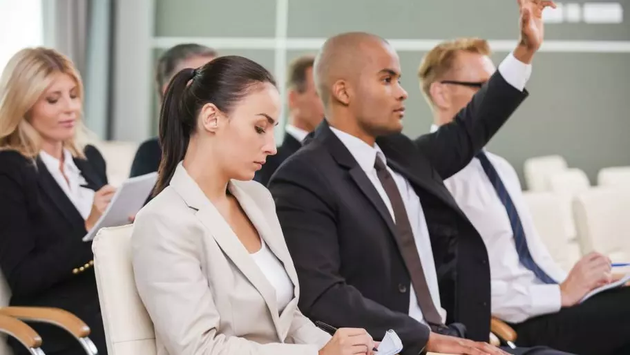 Participants on chairs with one hand raised