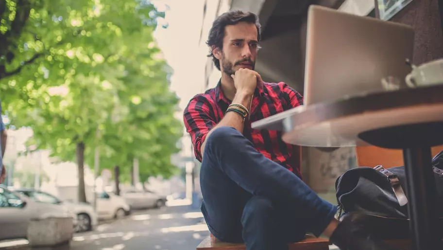 Man on laptop wondering why he needs insurance as a freelancer