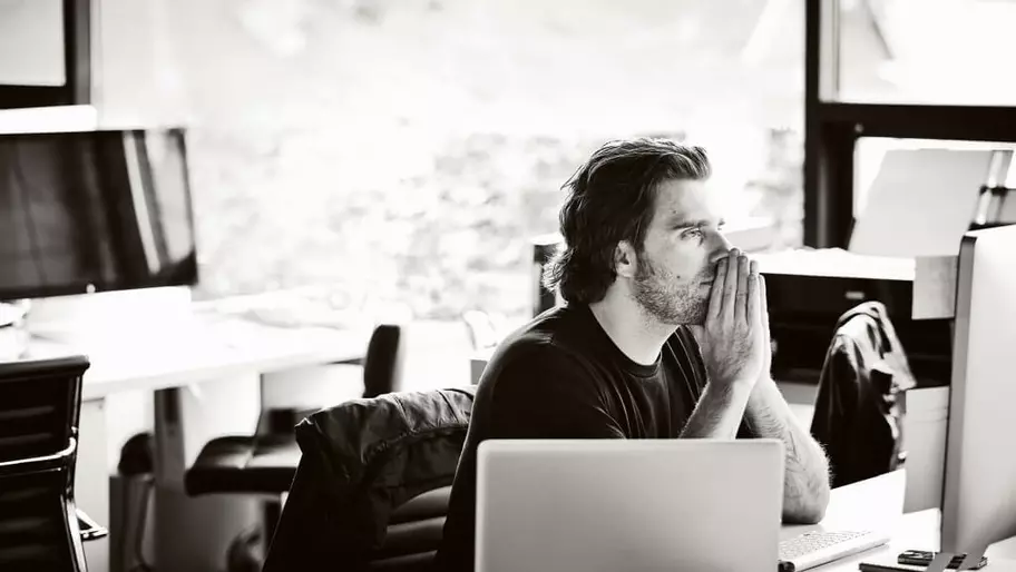 A man sitting in his home working on his computer