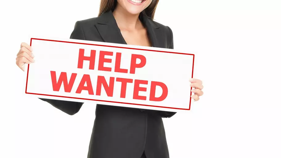 Woman holding a Help Wanted sign