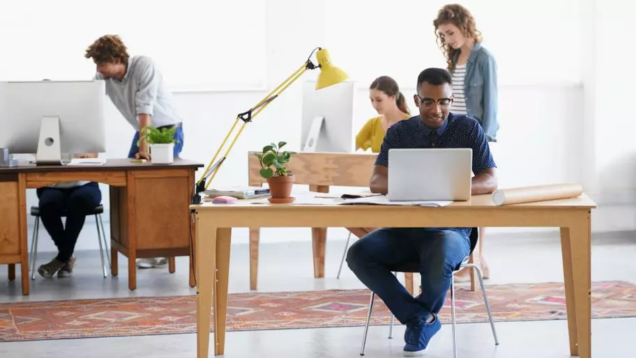 Employees work at desks and computers