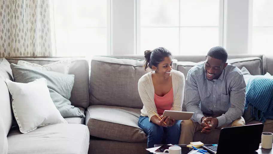 A couple sits on the couch discussing small business insurance
