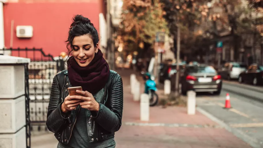 Woman on street looking at smart phone