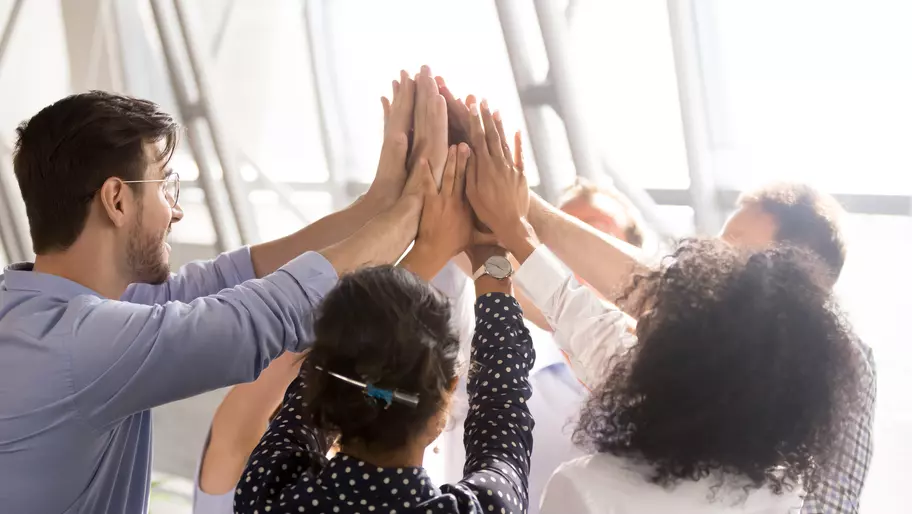 Group of diverse employees high-fiving