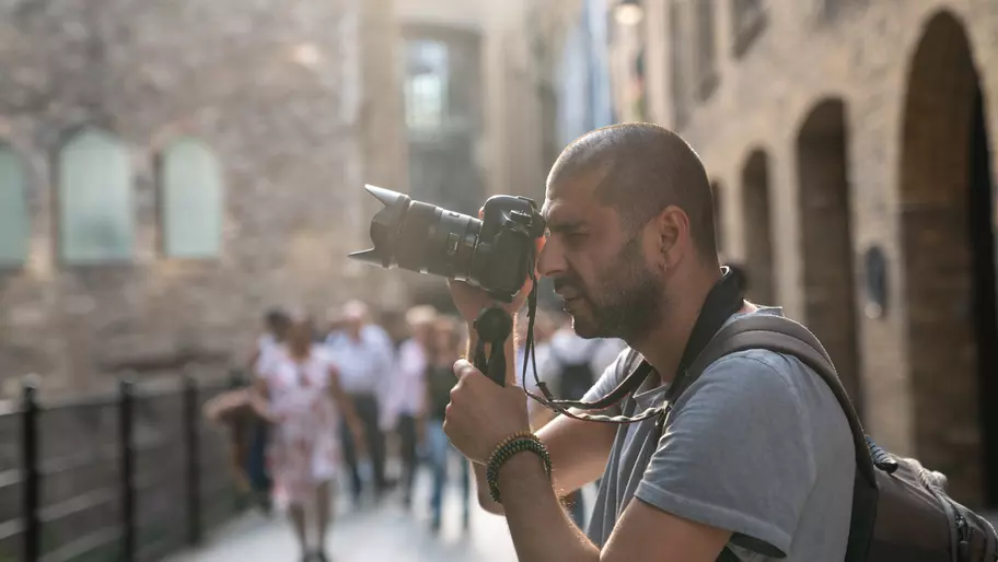 Male street photographer holding his camera and to take a picture.