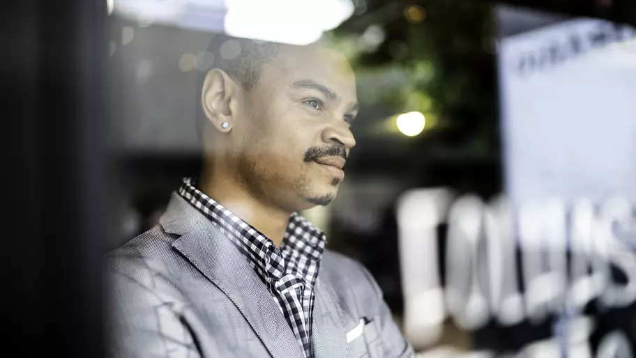 African American entrepreneur and businessman, staring out of window.