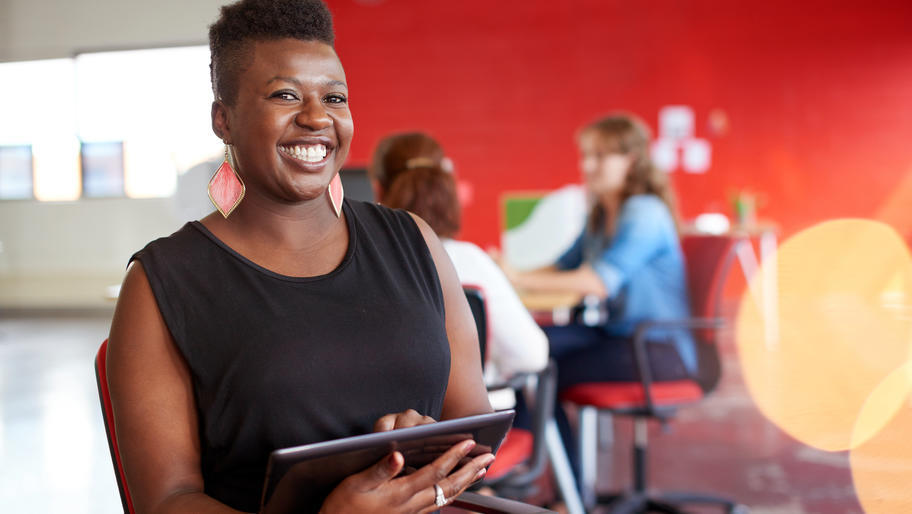 African American small business owner smiling with Ipad