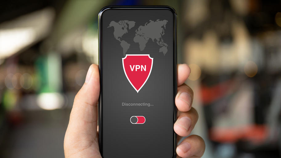 Man holding smart phone showing a VPN shield 