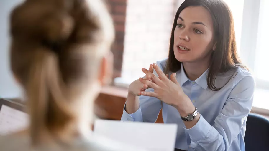 Young woman sitting and talking to colleague. HR professional, HR certification.