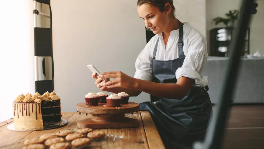 Bakery owner taking picture for social media.