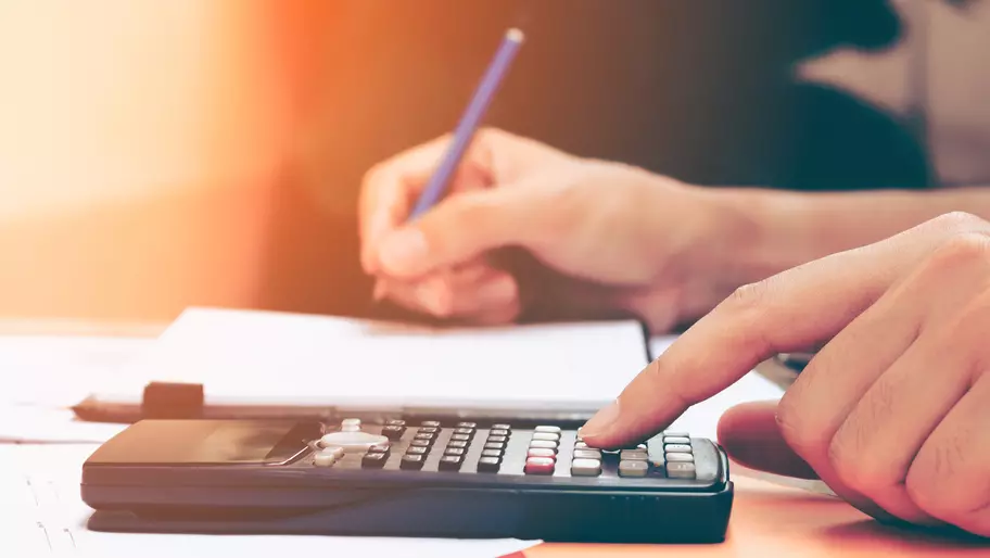 Close up of man's hand on calculator.