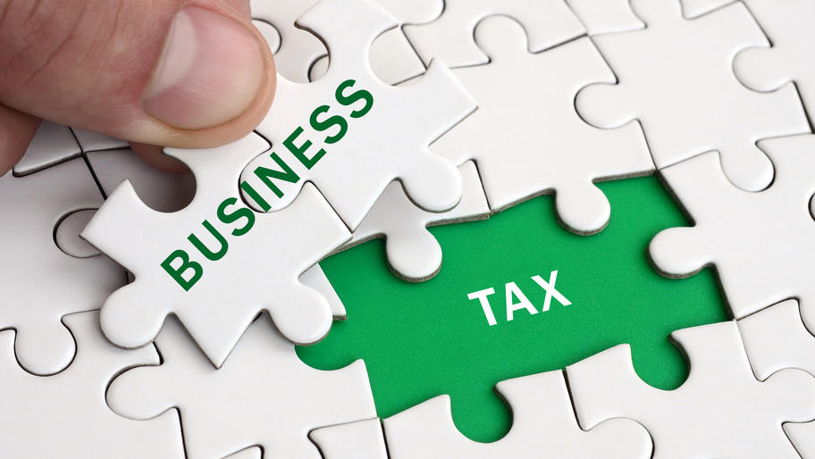 Green and white puzzle pieces with the words, "business tax."