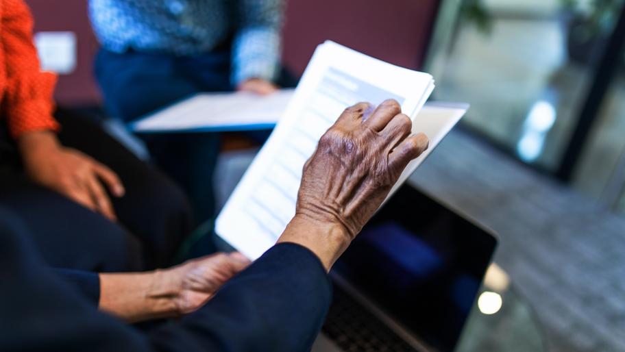 Woman's hands holding documents. Small business retirement plan.