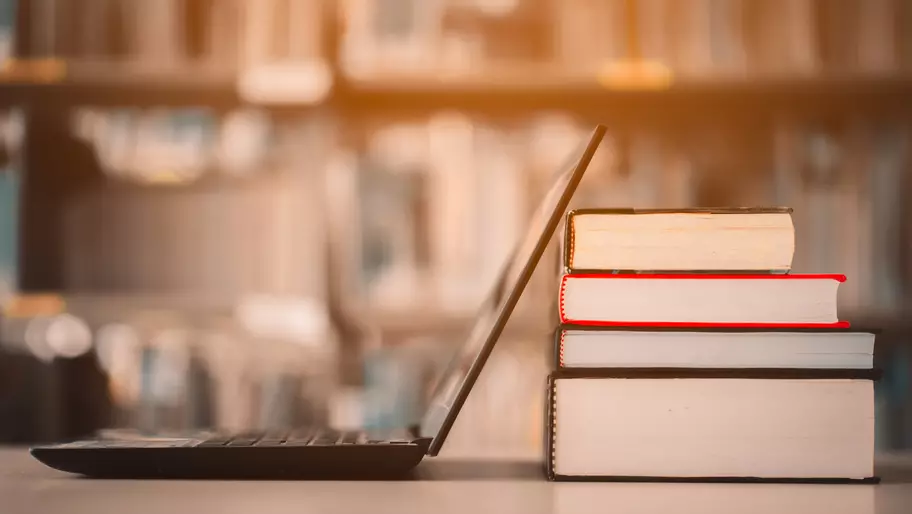 Cyber security IQ. Laptop propped up against library books.