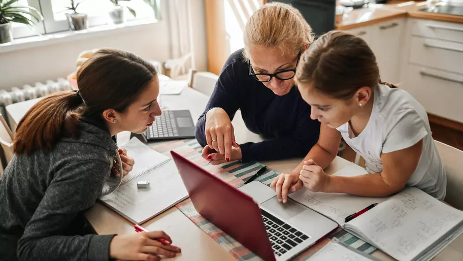 Mother helping homeschool her kids. Laptop notebook. Small business owner.