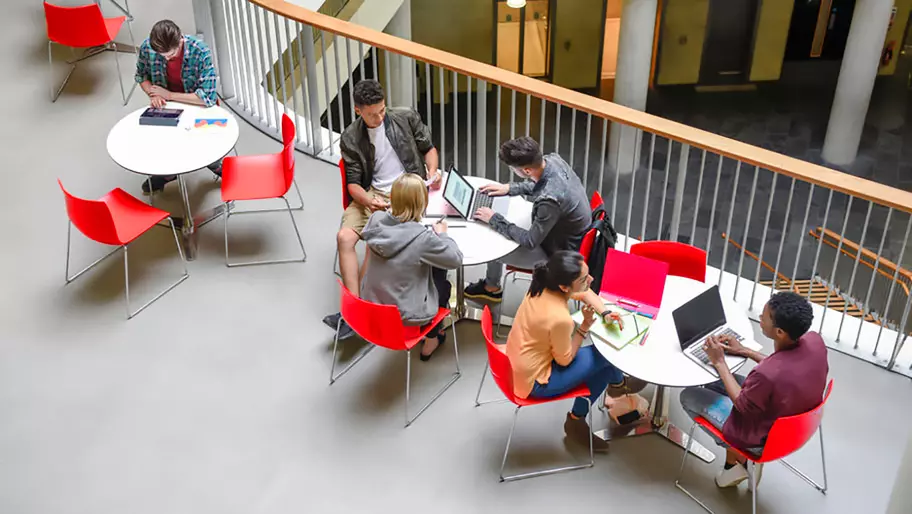 Students sitting around tables on campus