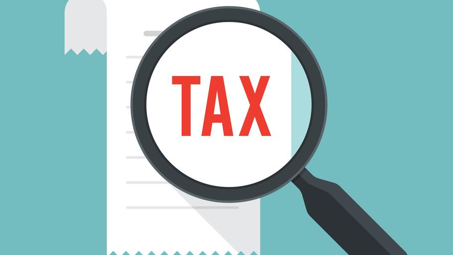 Scroll with the word 'tax' on it and magnifying glass. Tax-planning guide, checklist.