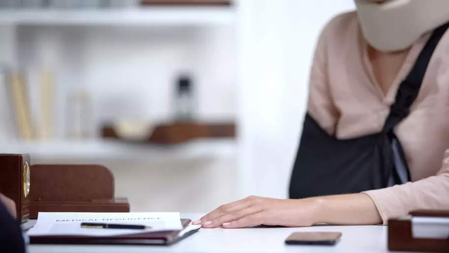 Woman at work with neck brace. Workers compensation insurance.