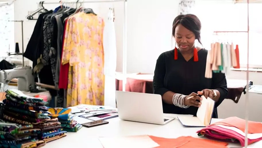 female entrepreneur sits at desk reading book