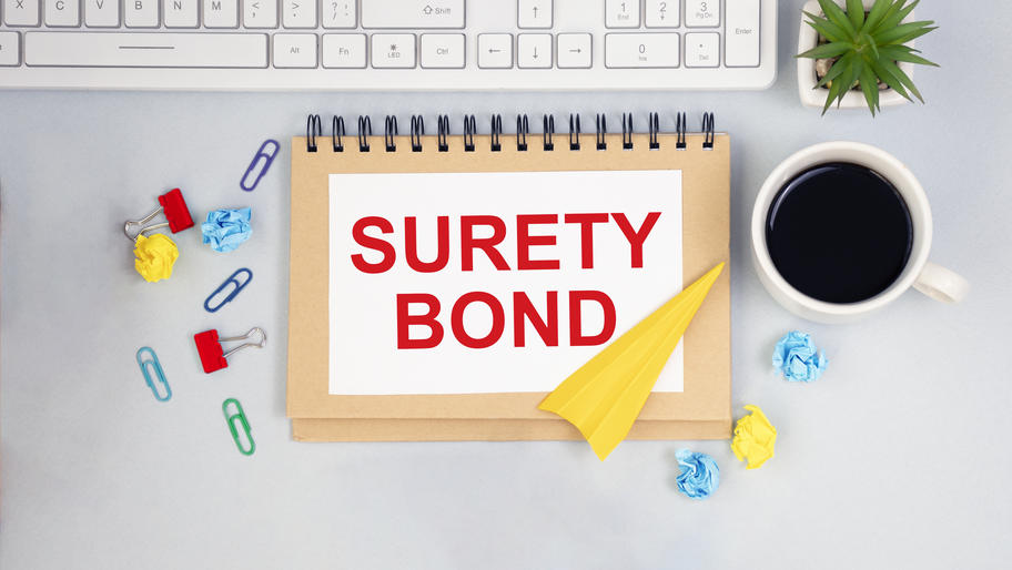 Surety bond card on desk with coffee to help you learn all you need to know about surety bonds