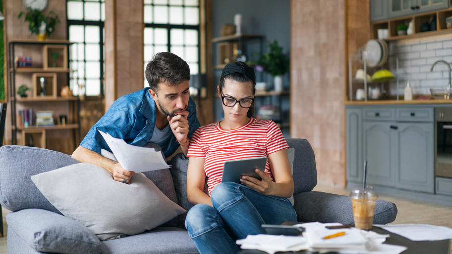 couple looking at small business tax deadlines while sitting on couch