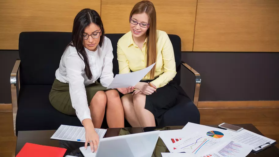 Female angel investor sitting alongside female entrepreneur disucssing funding plans