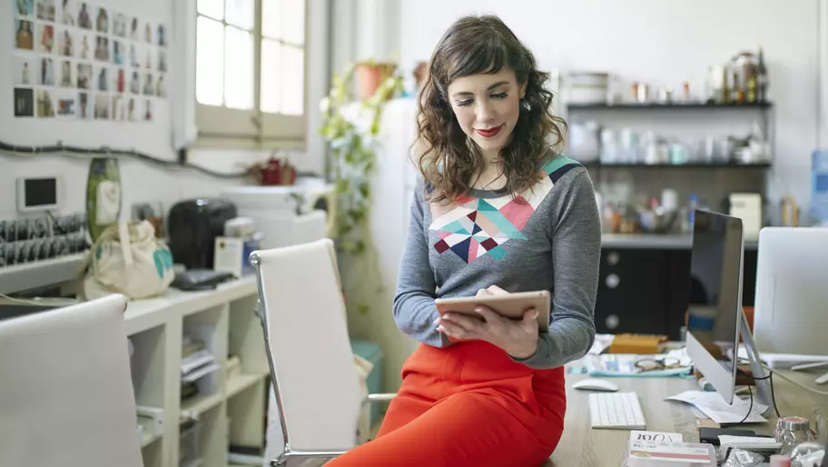 Female business owner in office using her tablet to get plans in place and set goals for Q2