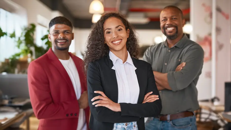 Three sibling entrepreneurs standing in an office two males on the left and right, female in the middle