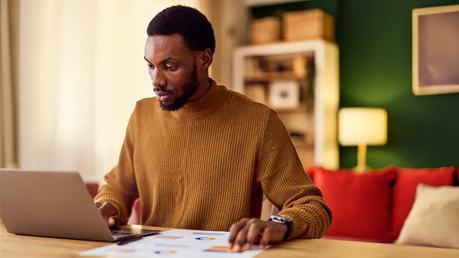 Business owner creating profit and loss statement on laptop
