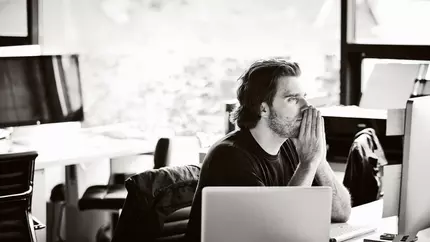 A man sitting in his home working on his computer