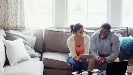 A couple sits on the couch discussing small business insurance
