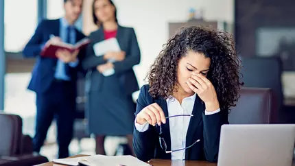 Woman with head down in workplace