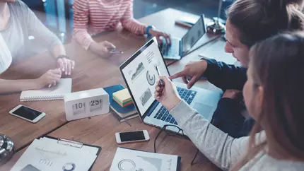 Small business marketers pointing at a laptop screen