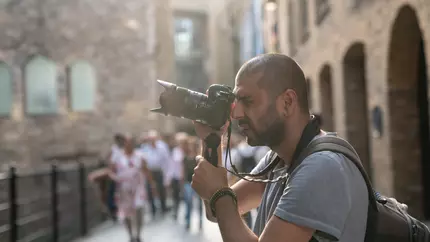 Male street photographer holding his camera and to take a picture.