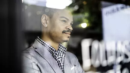 African American entrepreneur and businessman, staring out of window.