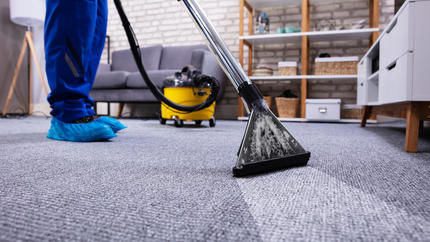 Professional carpet cleaner cleaning a living room carpet.