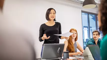 Woman standing in a meeting delivering a speech 