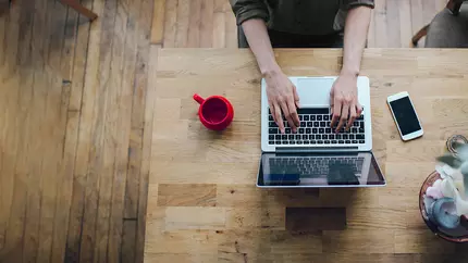 Man's hands on laptop keyboard. Man sitting at desk working from home.