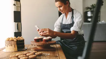 Bakery owner taking picture for social media.