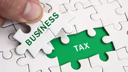 Green and white puzzle pieces with the words, "business tax."