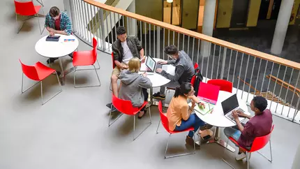 Students sitting around tables on campus