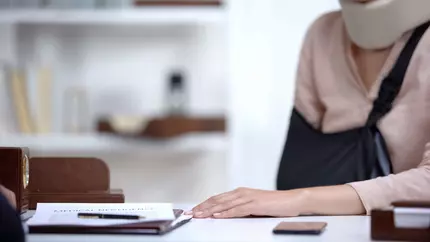 Woman at work with neck brace. Workers compensation insurance.