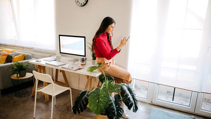 female entrepreneur works on her mobile device in office