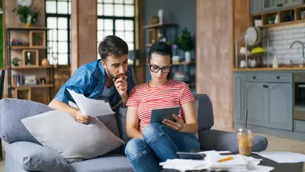 couple looking at small business tax deadlines while sitting on couch