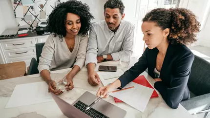 three employees sit in commercially leased space discussing small business