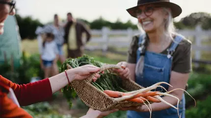 female buying and selling local goods at farmer's market supporting localism