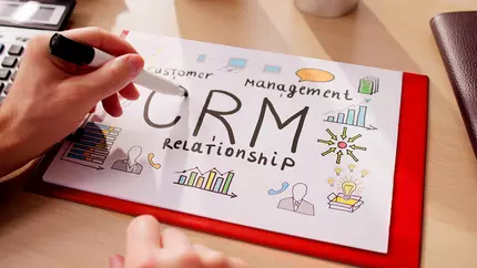 CRM info for small business written on white paper attached to clipboard