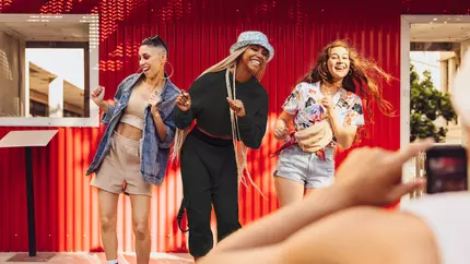 social influencers being demure, mindful, and cutesy with red backdrop 