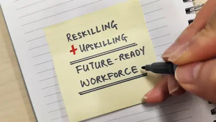 hand writing on yellow post-it note reskilling + upskilling = future-ready workforce