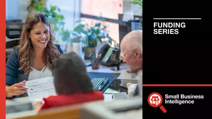 Friendly female banker assisting future business owners sitting across from her desk